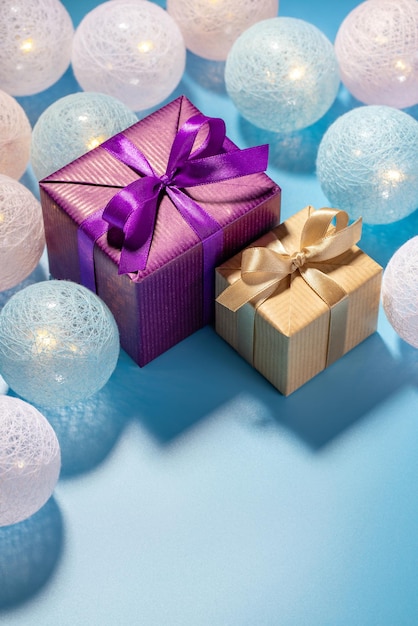 Kerst- en nieuwjaarsgeschenken in twee dozen op een blauwe achtergrond met gloeiende ballen Vakantieconcept