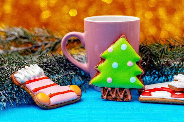 Kerst- en nieuwjaarskoekjes in de buurt van een mok met thee of koffie en dennentakken feestelijke kerstsfeer