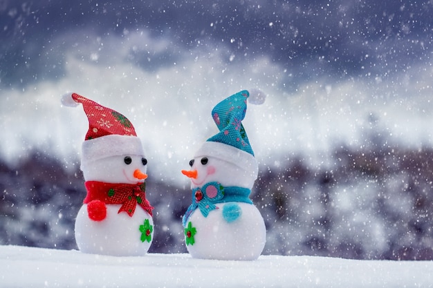 Kerst- en nieuwjaarswenskaart met twee sneeuwmannen op straat tijdens een sneeuwstorm