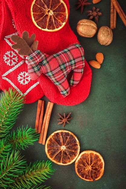 Kerst en oud en nieuw met dennentakken, brandende kaars, noten en kruiden, en rode sokken met een stuk speelgoed hertenstof. Bovenaanzicht