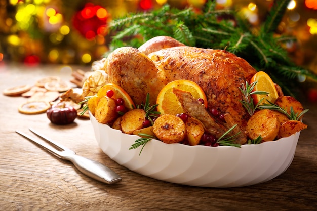 Kerst eten. Gebakken kalkoen gegarneerd met aardappel, sinaasappels en veenbessen op een houten tafel