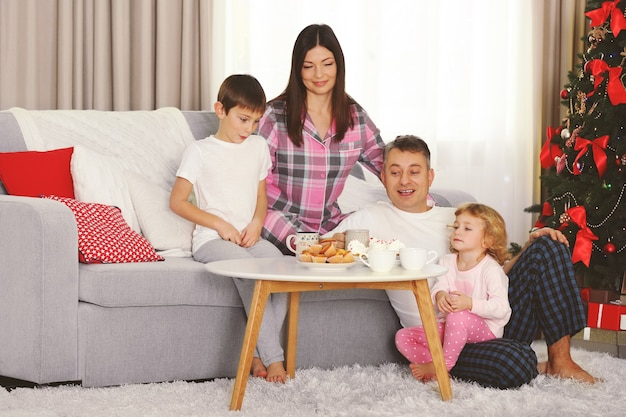 Kerst familieportret bij het ontbijt in de woonkamer van de huisvakantie, 's ochtends