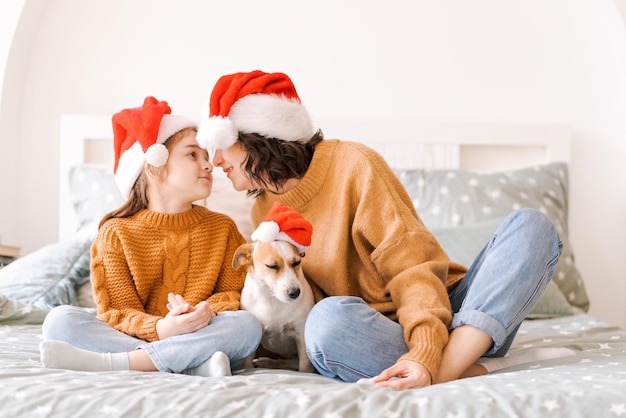 Kerst familieportret op bed in slaapkamer baby en hond spelen moeder