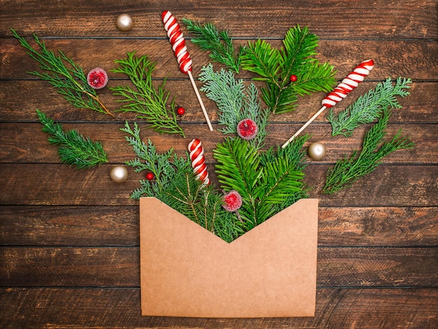 Kerst feestelijke achtergrond met envelop vol naaldtakken Kerstsnoepjes ornamenten