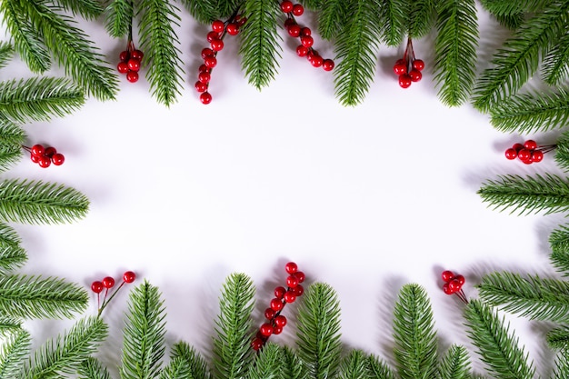 Kerst frame achtergrond met fir takken en hulst bessen. Kopieer ruimte.