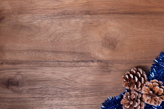 Kerst frame dennenappels en blauw klatergoud op houten achtergrond