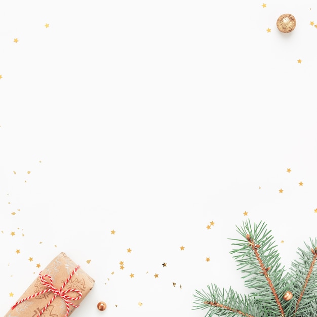 Kerst frame van groene takken, geschenken, gouden versieringen op witte achtergrond.
