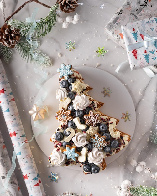 Foto kerst fruitcake versierd meringue peperkoek koekjes sneeuwvlokken bosbes verticaal