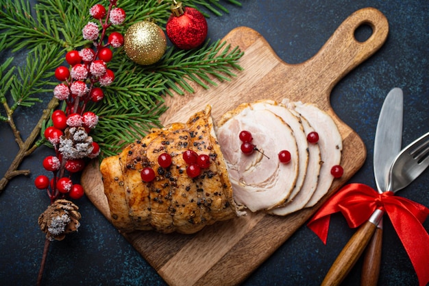 Kerst gebakken ham gesneden met rode bessen en feestelijk