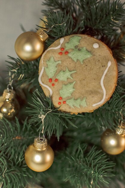 Foto kerst gemberbrood op de achtergrond van een kerstboom met gouden ballen