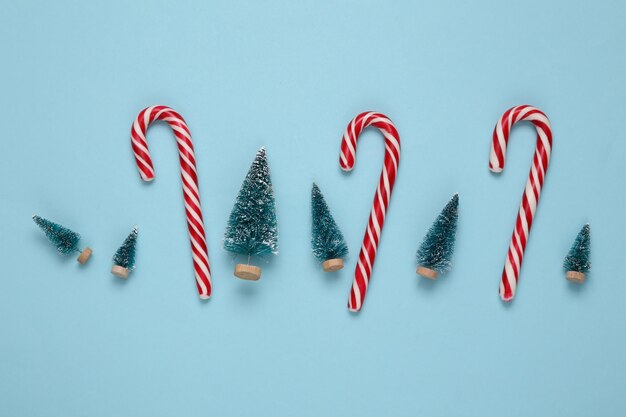 Kerst gestreepte zuurstokken en mini kerstbomen op een blauwe achtergrond Nieuwjaar xmas achtergrond