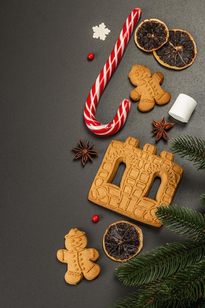 Kerst gingerbread house koekjes koekje. traditioneel feestelijk nieuwjaarsdecor. zwarte stenen betonnen achtergrond, levensstijl, plat, bannerformaat