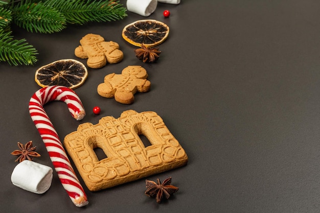 Kerst gingerbread house koekjes koekje. traditioneel feestelijk nieuwjaarsdecor. zwarte stenen betonnen achtergrond, levensstijl, plat leggen, kopieer ruimte