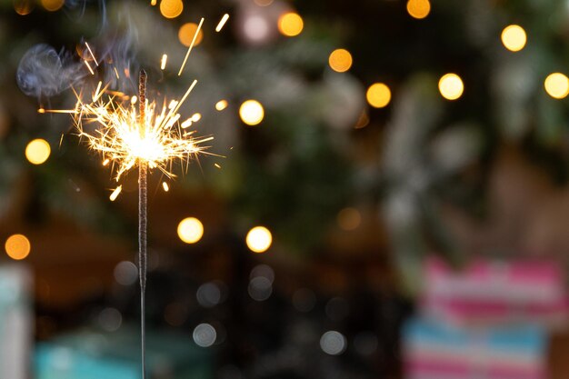 Kerst glinsterende wonderkaarsen kaars brandt in kerstboom achtergrond Xmas verlichting decoratie thuis binnen Feestelijke magie vonken lichten voor vakantie feest Kerstavond met vuurwerk