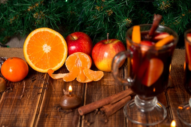 Kerst glühwein met fruit en kruiden op houten tafel. Kerstmisdecoratie op achtergrond.