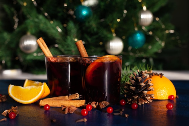 Kerst glühwein met kaneelstokje, sinaasappel, anijs en kruidnagel op een blauwe achtergrond. Kerstvakantie.