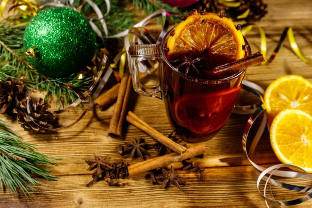 Kerst glühwein met kruiden en kerstversiering op houten tafel