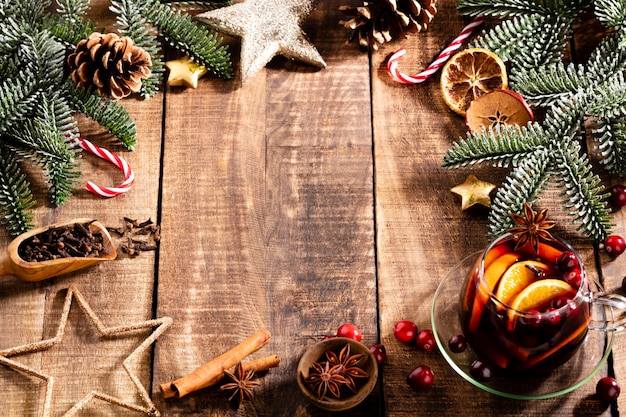 Kerst glühwein met kruiden op een rustieke houten tafel.