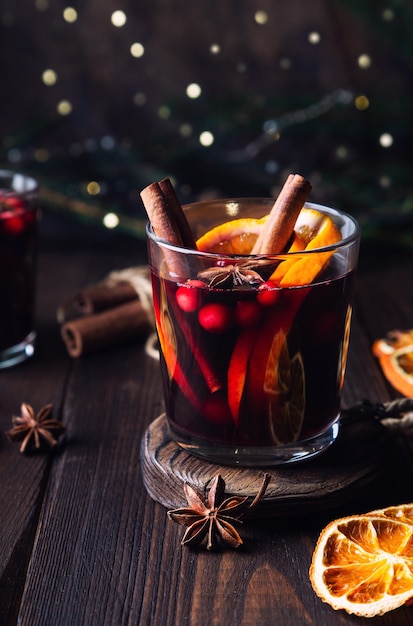 Kerst glühwein met veenbessen sinaasappel en kruiden op rustieke houten achtergrond