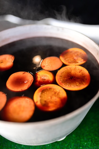 Kerst glühwein op de kermis gebrouwen in een ketel met kaneel en citrus Koken van een traditioneel kerst- en nieuwjaarsdrankje