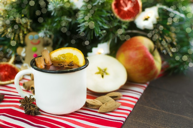 Kerst glühwein warme compote in een witmetalen mok met gedroogde vruchten anijs kaneel sinaasappels