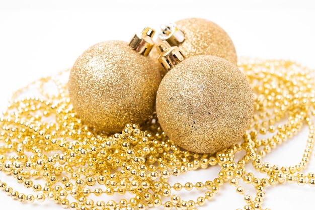 Kerst gouden bal voor kerstboomversiering en vakantieversieringen op witte achtergrond, kerstspeelgoed, close-up