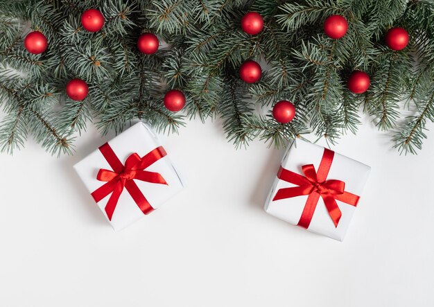Kerst grens met Spar takken, rode ballen en geschenken op een witte achtergrond.