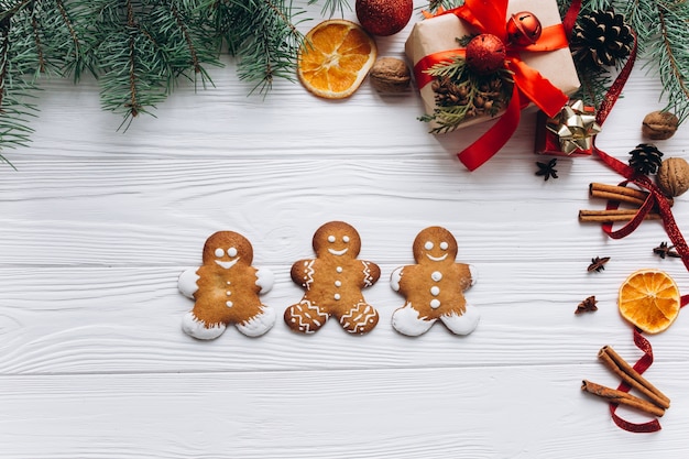 Kerst grens. peperkoekkoekjes, kruiden en decoratie op witte houten achtergrond.