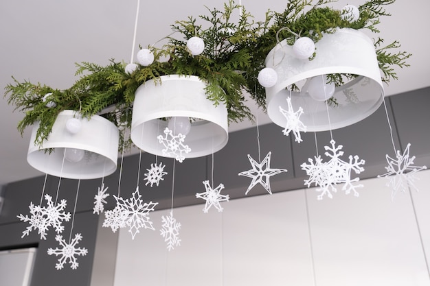 Kerst interieurdecoratie witte gebreide sneeuwvlokken dennentakken en kerstverlichting op een kroon...