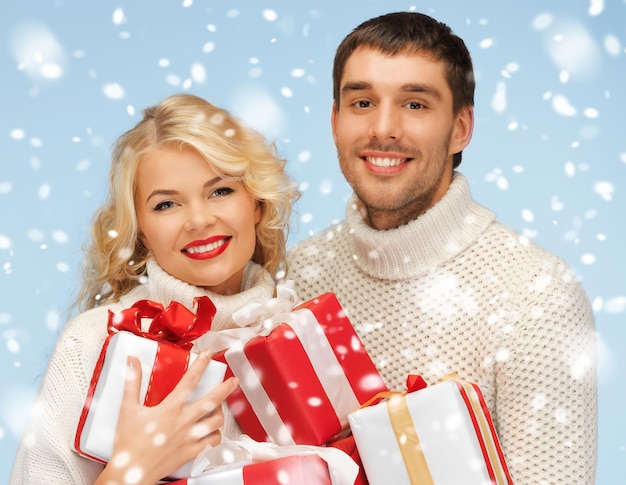 Kerst, kerst, winter, geluksconcept - gelukkige man en vrouw met veel geschenkdozen