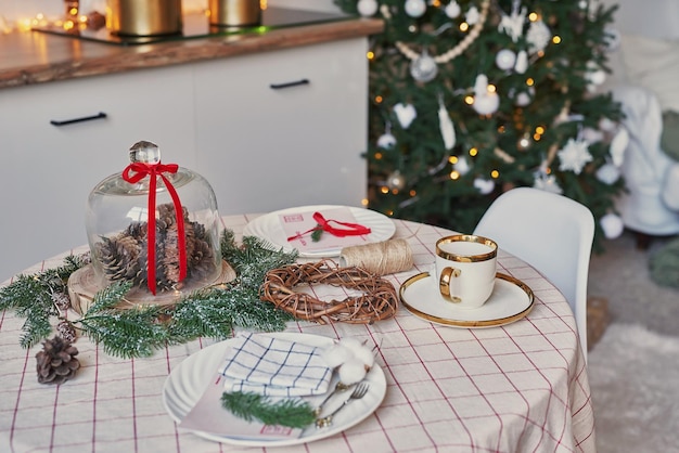 Kerst keuken en tafel. Rode, groene en witte decor kerstboom achtergrond. Nieuwjaarsviering. Vrolijk kerstfeest en een gelukkig nieuwjaar.