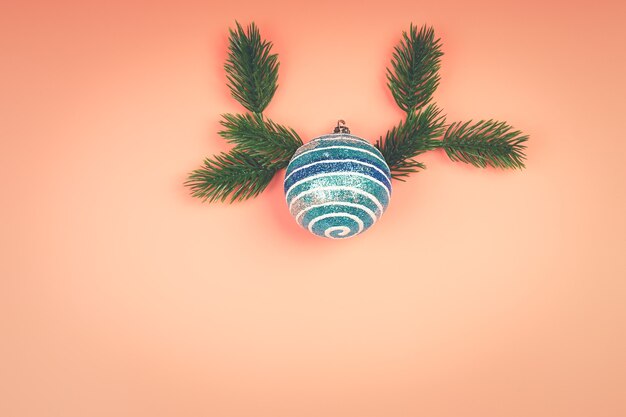 Kerst lay-out blauw glitter Kerst bal met vuren takken op een roze achtergrond. Plaats voor tekst, vlakke stijl, bovenaanzicht. Minimalistische Scandinavische stijl.