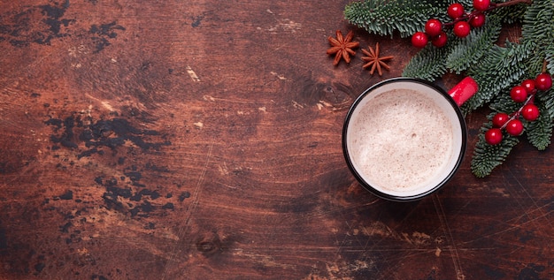 Kerst met warme chocolademelk, spar takken en holly.