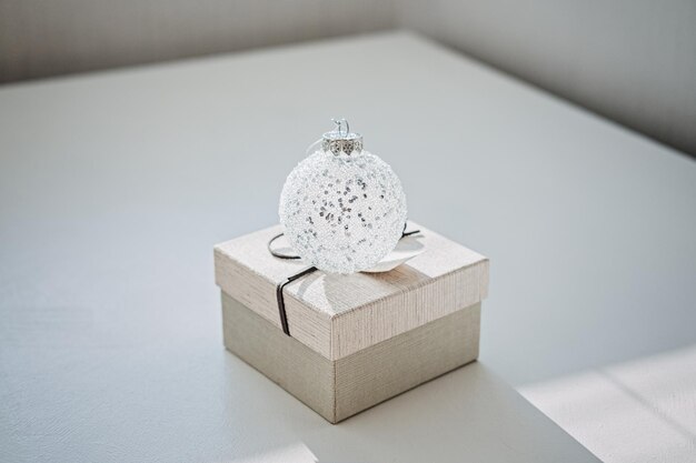 Kerst minimale webbanner met kerst ornament bal en geschenkdoos op lichte achtergrond kerstmis