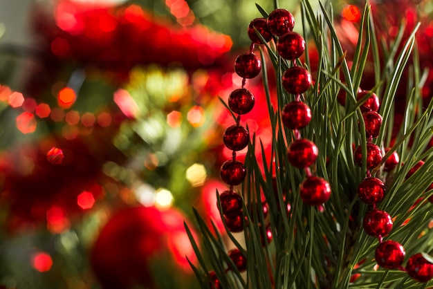 Foto kerst mis of nieuwjaar rode decoratieve bal op een feestelijk versierde boom kerstmuur selectieve soft focus bokeh