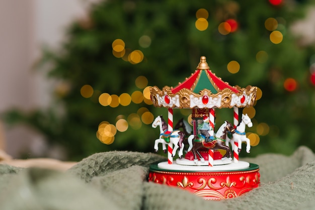 Kerst muzikale speelgoed carrousel op de achtergrond van de brandende lichten van de kerstboom.