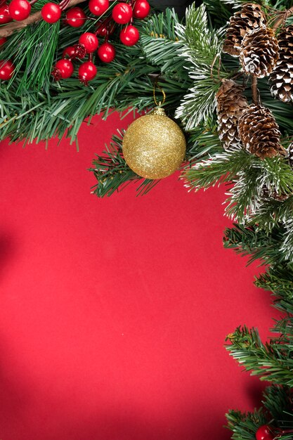 Kerst-nieuwe jaar samenstelling whit een rode achtergrond. Denneappels, dennentakken en kerstballen docoration. Plat leggen, bovenaanzicht, kopie ruimte