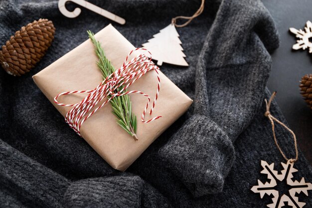 Kerst- of winterstilleven met geschenkdoos en houten speelgoed op een wollen trui