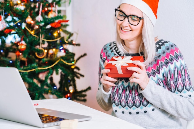 Kerst online gefeliciteerd lachend meisje thuis met behulp van laptop computer notebook voor video