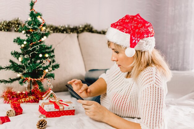 Kerst online winkelen. vrouwelijke koper maakt bestelling op mobiele phone.ys verkoop.