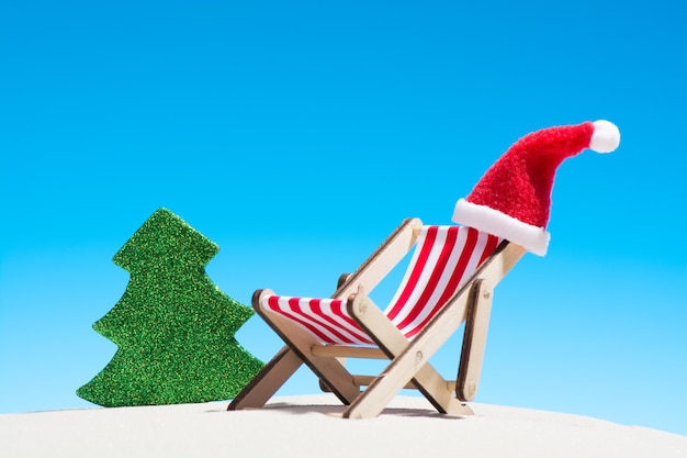 Kerst op het strand: een luie stoel met kerstmuts en speelgoedspar