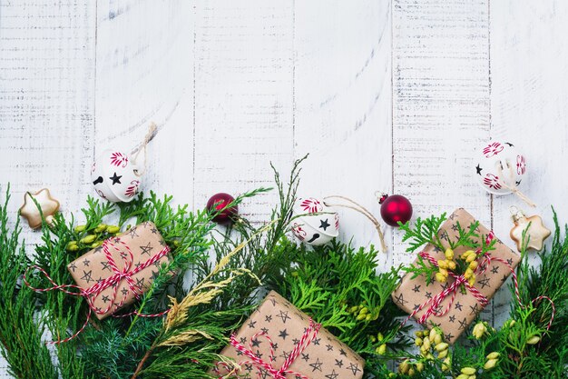 Kerst oppervlak met dennentakken, speelgoed, geschenkdoos en klokken op houten oude oppervlaktetafel