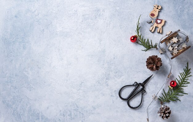 Kerst plat lag met groene boom, rode ballen, houten speelgoed en kegels op blauwe achtergrond. afbeelding bovenaanzicht en kopieer ruimte