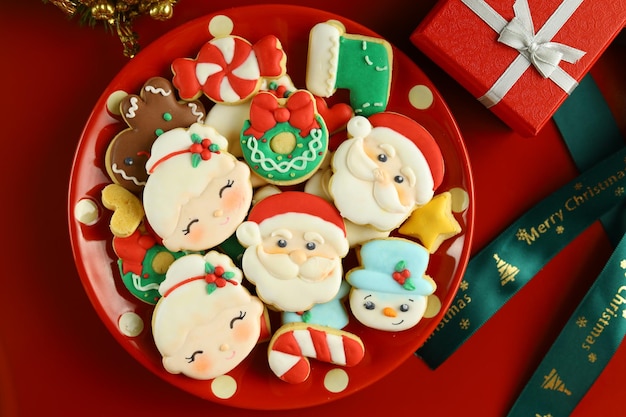 Kerst poedersuiker koekjes en geschenkdoos met rode achtergrond en ornamenten.