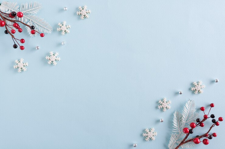 Foto kerst rand gemaakt van sneeuwvlokken en rode bessen op blauwe ondergrond
