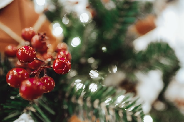 Kerst rode bessen hangen aan de kerstboom. Kerstsfeer en nieuwjaarssfeer. Feestelijk behang