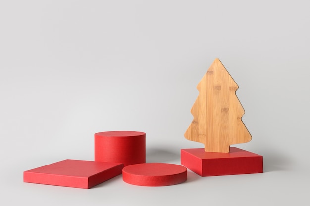 Kerst rode standaards met cadeau en decoratieve houten creatieve kerstboom. Moderne podium achtergrond.