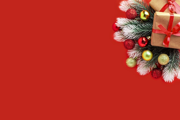 Kerst samenstelling. geschenkdoos, dennentakken, rode gouden ballen op rood, nieuwjaarsconcept. plat leggen, bovenaanzicht, kopie ruimte