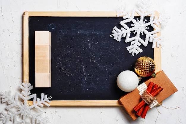 Kerst samenstelling nieuwjaarscadeau en ballen sneeuwvlokken op blackbord achtergrond plat lag bovenaanzicht c...