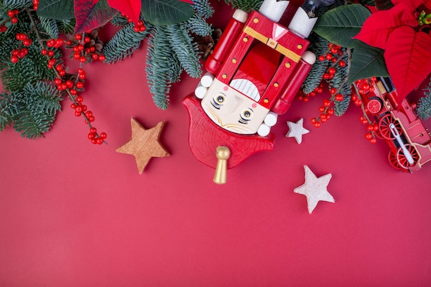 Kerst samenstelling. Rode kerstversiering, spar takken met speelgoed geschenkdozen op rode achtergrond. Plat lag, bovenaanzicht, kopie ruimte